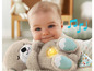 Dítě drží plyšovou hračku Fisher-Price se světlem a zvukem.