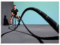 Muž cvičí s těžkým lanem na fitness.