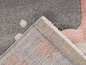Detailní pohled na růžový a šedý koberec s puntíky.