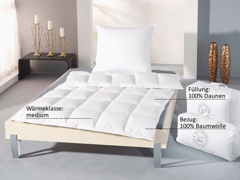 Bílé peřina z peří s bavlněným povlakem, představená na posteli.