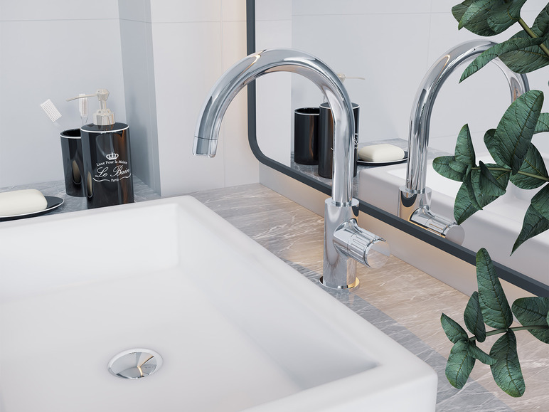 Koupelna s bílým umyvadlem, dvěma chromovými bateriemi a dávkovačem od Le Bain.