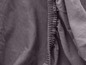 Detail šedé látky s elastickým lemem.