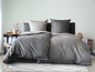 Šedá souprava ložního prádla s polštáři.