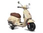 Bílý elektrický skútr pro děti ve stylu Vespa.