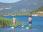 Dva lidé na paddleboardech, veslují na jezeře.