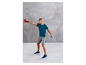 Muž ve sportovním oblečení s červenou kettlebell během tréninku.
