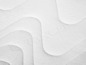 Detailní záběr na bílý matraci s vlnitým vzorem.