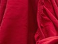 Detail červené látky s gumičkou.