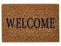Vítací rohož s nápisem 'WELCOME'.