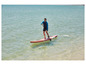 Muž pádluje na červeném paddleboardu Red Paddle Co.