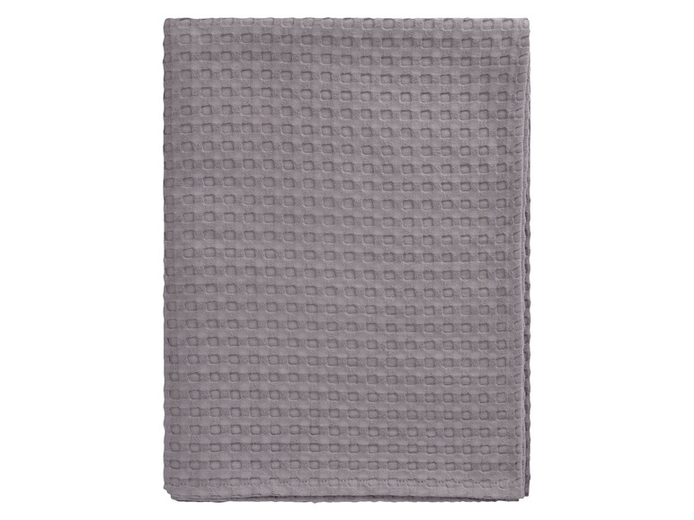 Šedá froté deka s kostkovaným vzorem.