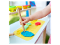 Dítě si hraje s plastelínou Play-Doh a formovacími nástroji u dřevěného stolu.