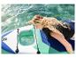 Žena na paddleboardu s průhledným oknem, dotýkající se vody.