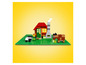 Lego domeček s kravou a ovci na zelené podložce.