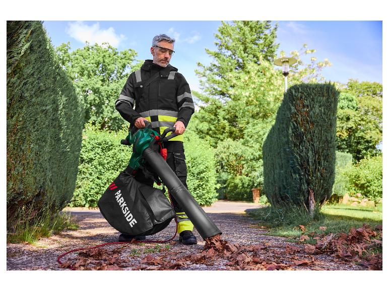 Muž používá fukar na listí Parkside, aby shrabal listí na příjezdové cestě.