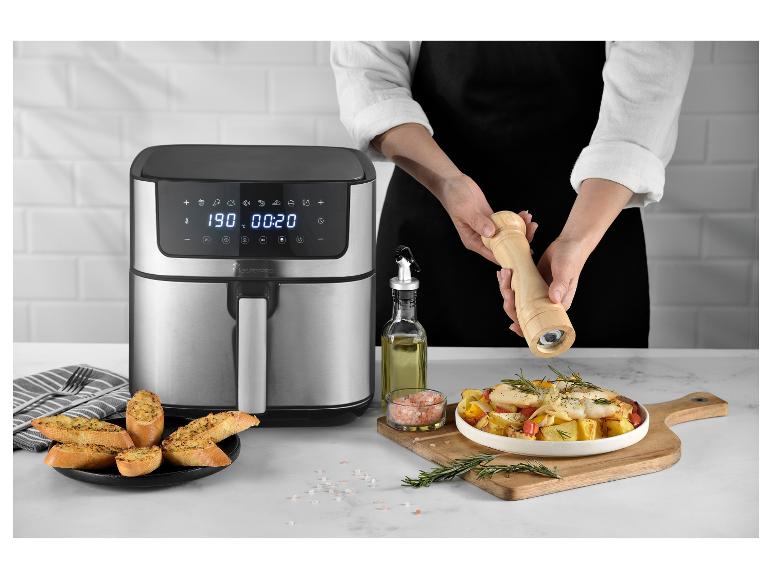 Horkovzdušná fritéza MasterPRO s uvařeným jídlem a osobou, která koření.