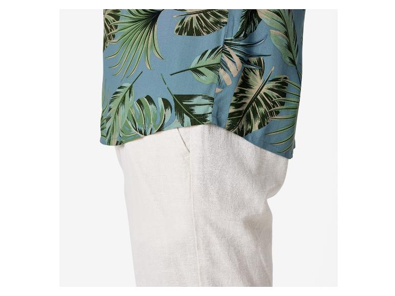 Košile s tropickým vzorem a béžové lněné kalhoty.
