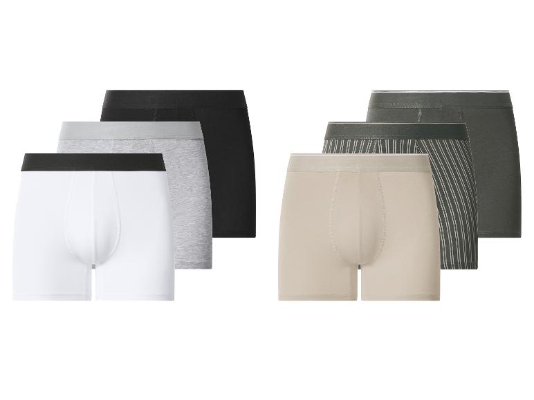 Sada pánských boxerek v různých barvách: bílá, šedá, černá, béžová a tmavě zelená.