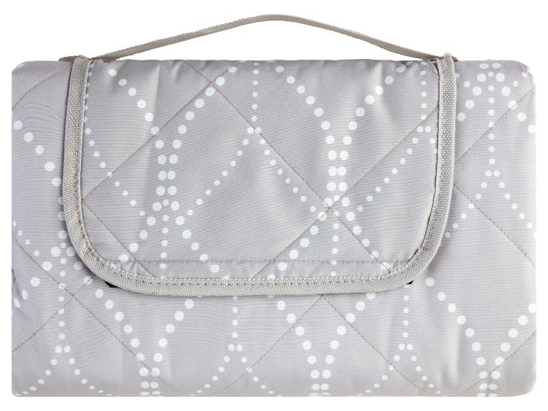 Šedá prošívaná pikniková deka s bílými puntíky.