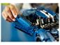 Osoba sestavuje modrý model LEGO Technic Ford GT.