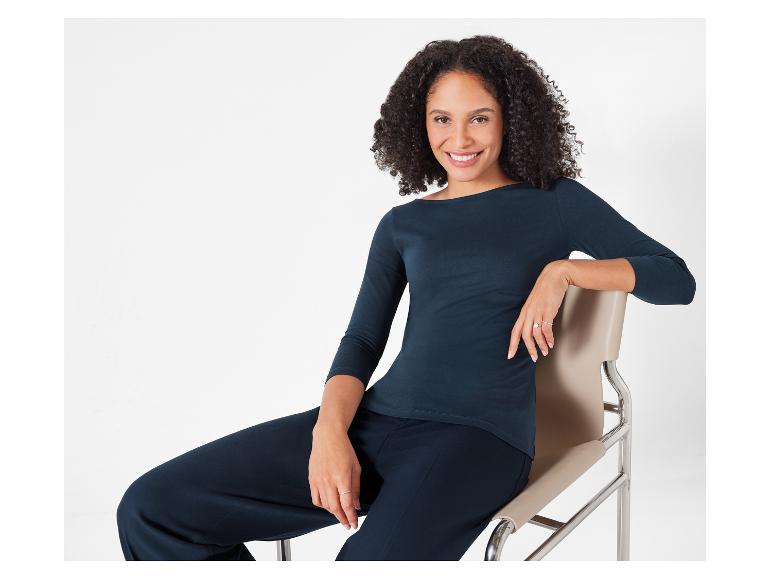 Žena v tmavě modrém tričku a kalhotách.