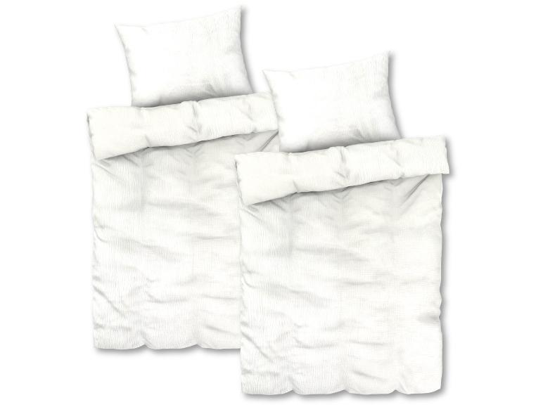 Bílé povlečení se dvěma polštáři.