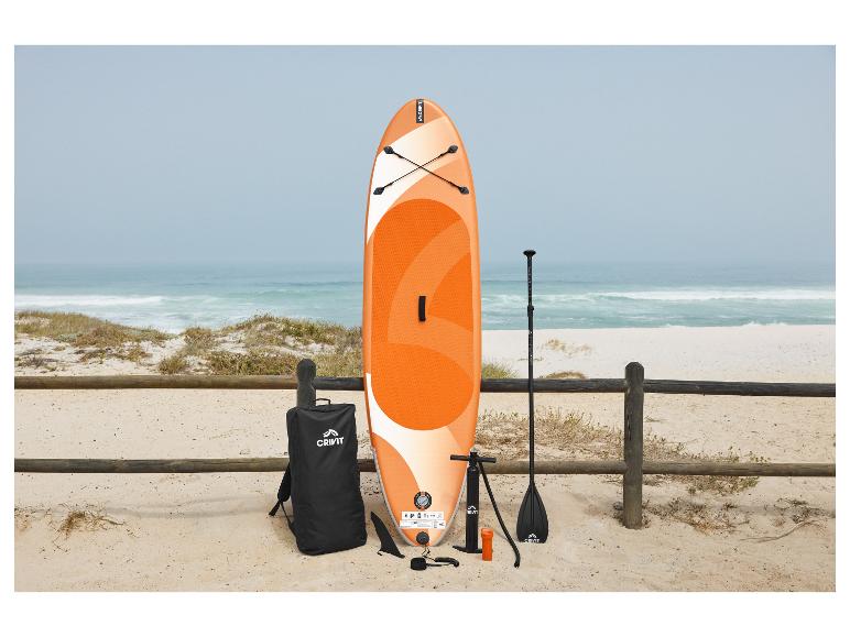 Oranžový a bílý paddleboard s příslušenstvím na písečné pláži u moře.