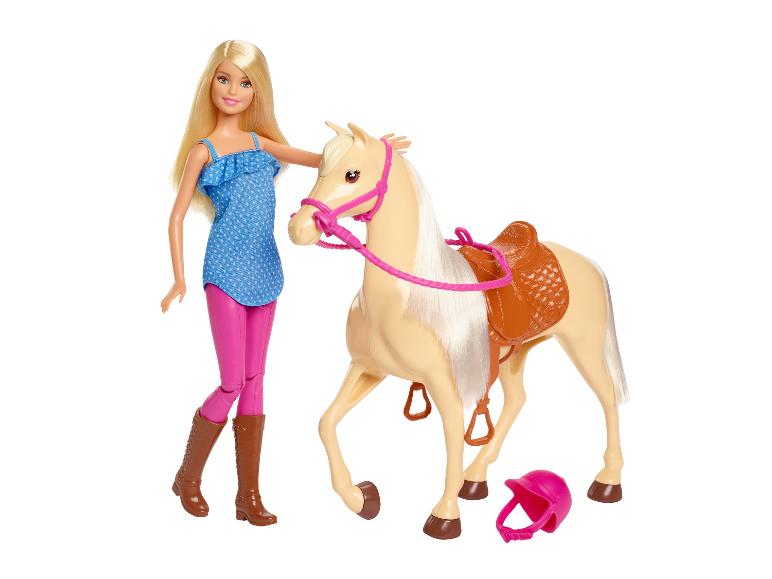 Panenka Barbie s blond vlasy, v růžové a modré, vedle béžového koně se sedlem.