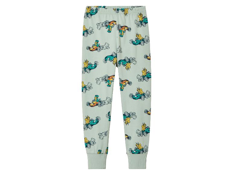 Světlé zelené kalhoty s potiskem dinosaurů v závodních autech.