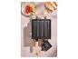 Raclette gril se zeleninou a chlebem na stole.