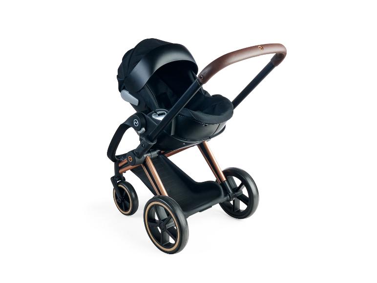 Kočárek Cybex Priam s černou korbou a koženou rukojetí.