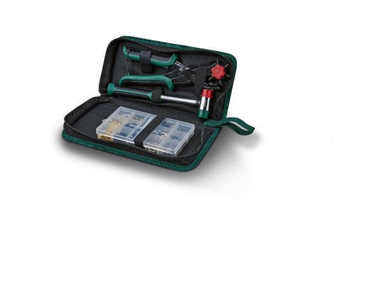 Zelená sada nářadí s kleštěmi, kladivem a drobnými díly v pouzdře.