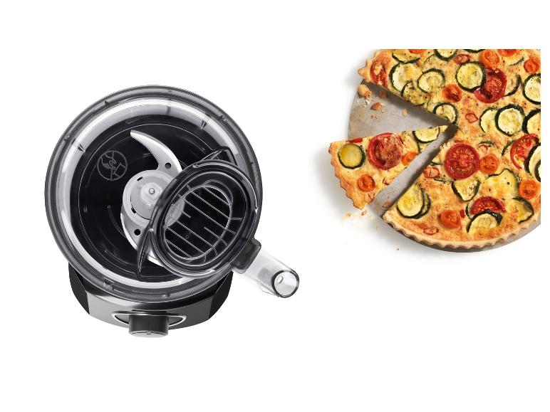 Food procesor s nožem a quiche s cuketou a rajčaty.