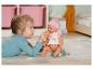 Holčička krmí panenku Baby Born z lahve.
