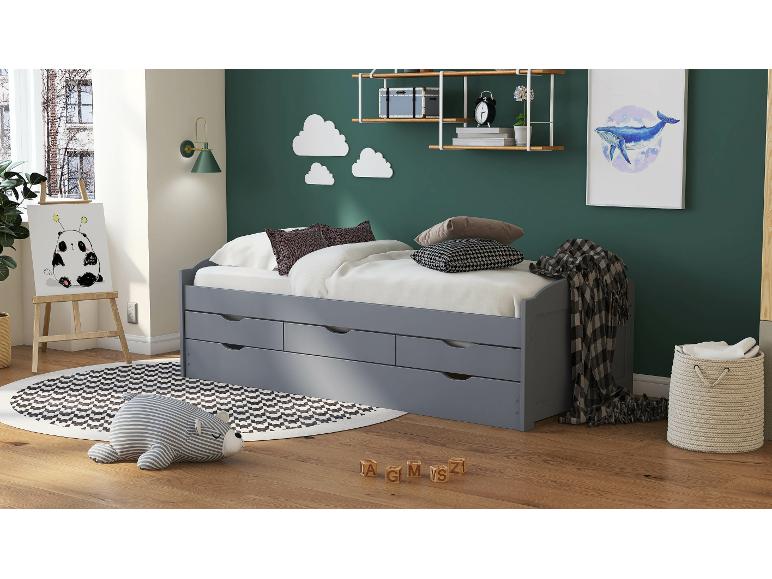 Šedá postel se třemi zásuvkami a pruhovaným kobercem v dětském pokoji.