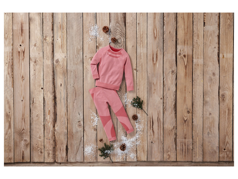 Růžová teplákovina s dlouhým rukávem a legínami na dřevěném pozadí