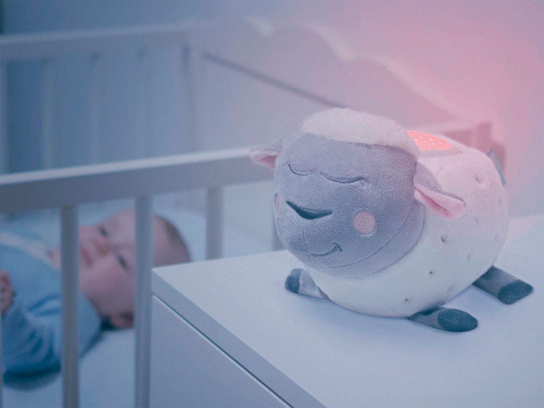 Šedá a bílá lampa ve tvaru ovce na nočním stolku.