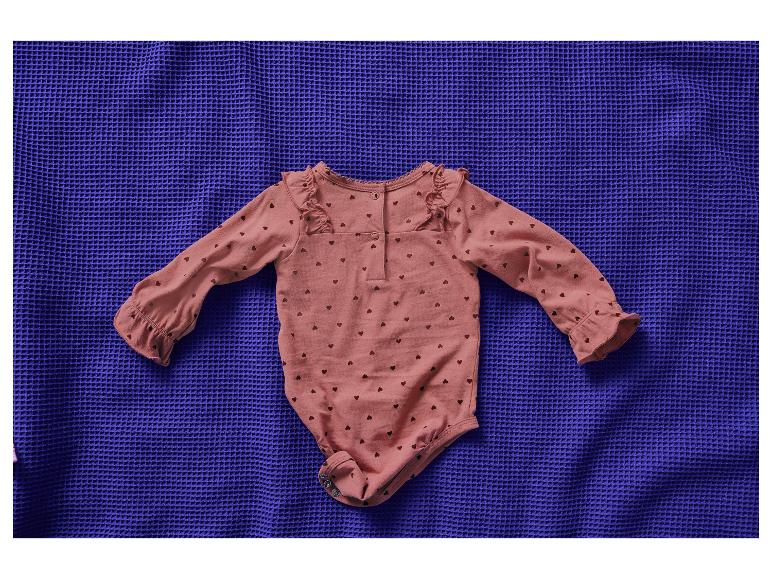 Růžové dětské body se srdíčky na modré dece