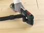 Zelený multitool Bosch s vysavačem pro zpracování dřeva.
