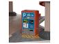 Červený a šedý parkovací automat na dřevěné podlaze se žlutým značením.