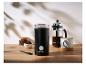 Kávomlýnek SilverCrest, french press a šálek kávy na dřevěném stole.