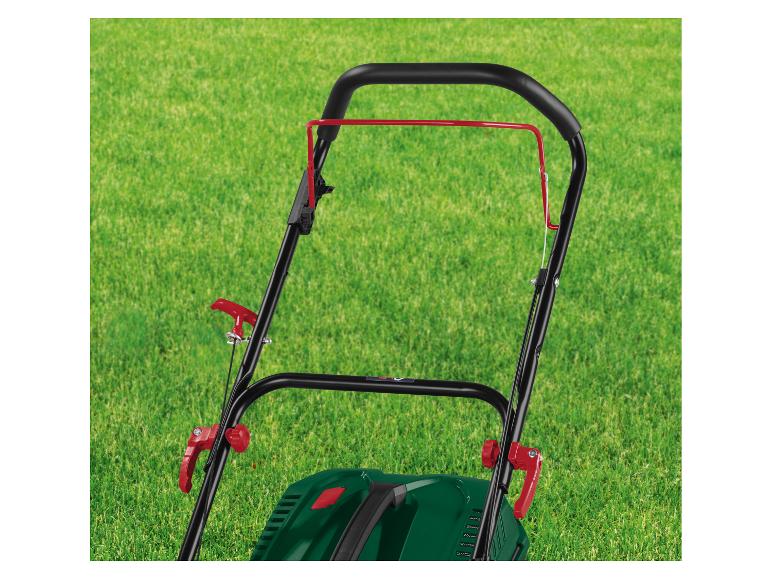 Rukojeť sekačky s červenými pákami na zeleném trávníku
