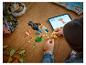 Dítě staví papouška LEGO Creator 3-v-1, sledujíc pokyny na tabletu.