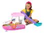 Usmívající se dívka si hraje s růžovou hračkou lodi Barbie, se skluzavkou a doplňky.