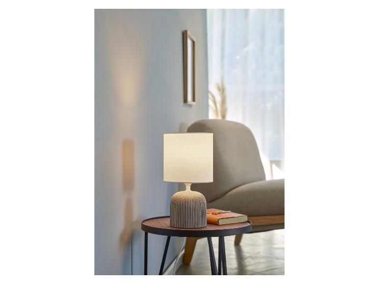 Moderní stolní lampa v minimalistickém stylu na příručním stolku.