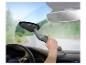 Ruka používá šedý autový vysavač v autě.