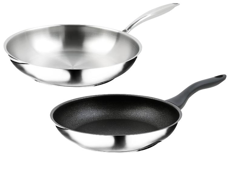 Dvě pánve: nerezový wok a pánev s černým nepřilnavým povrchem.
