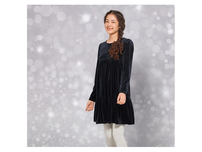 Dívka v černých sametových šatech a šedých legínách.