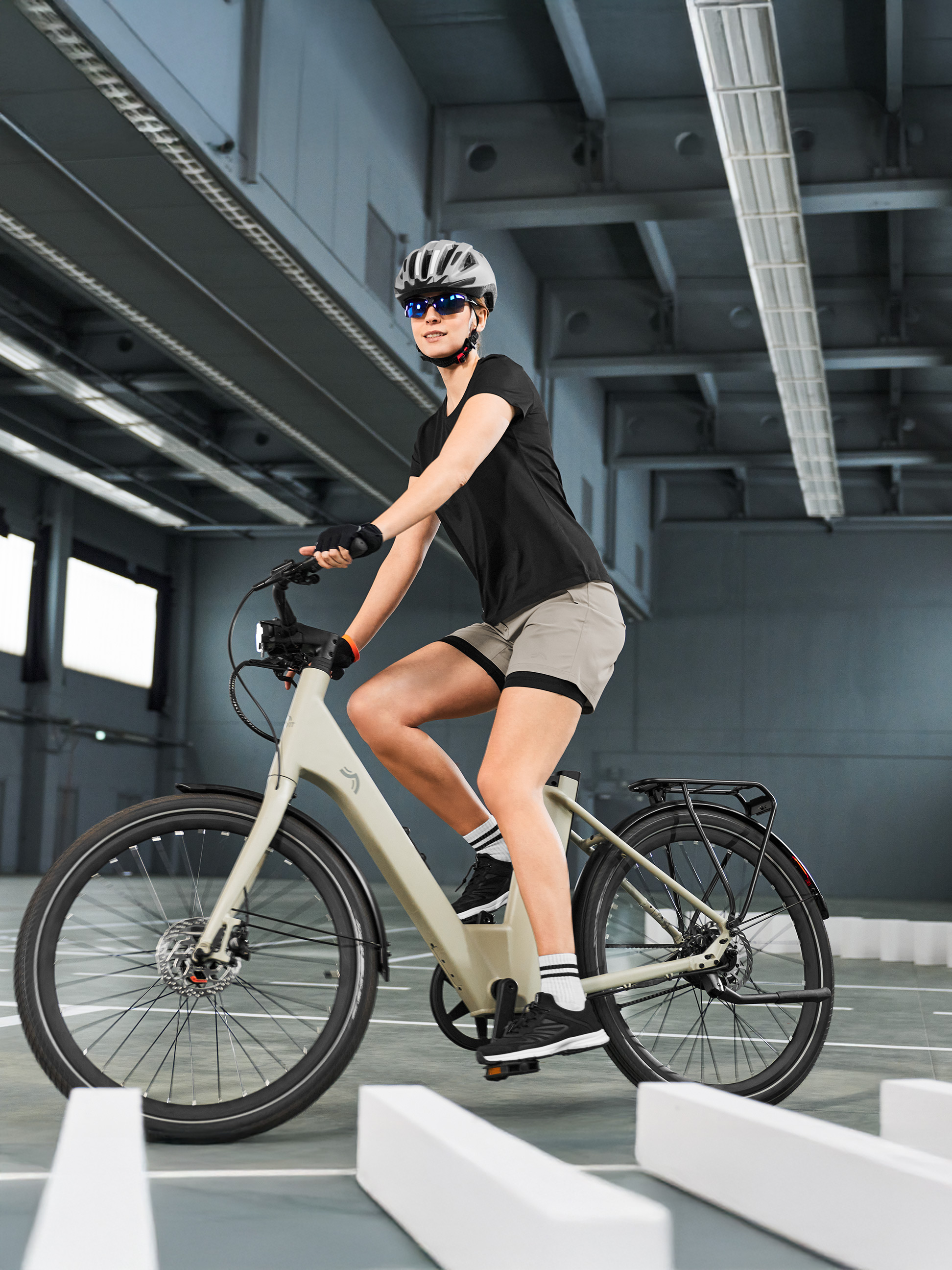 Žena v cyklistickém oblečení na elektrokole, projíždějící vnitřní dráhou.