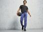 Muž v černém tričku a modrých teplákách drží medicinbal.